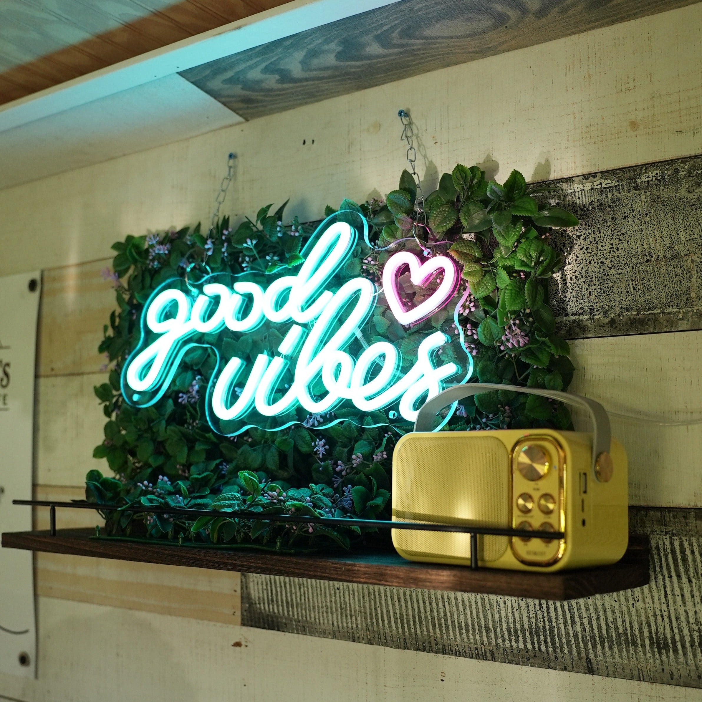 Neon sign with decorative plants on a wooden panel background